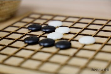 碁石が入った籐の碁笥（ごけ）が2つと、碁石を入れたプラスチックケースも写っている