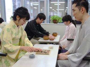 和服女性（左）と柿島（右）がアイゴツーで対局中の写真